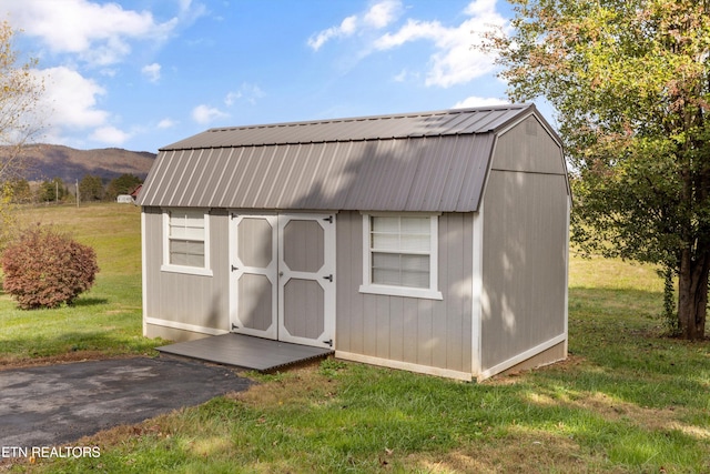 view of outdoor structure with a mountain view and a yard