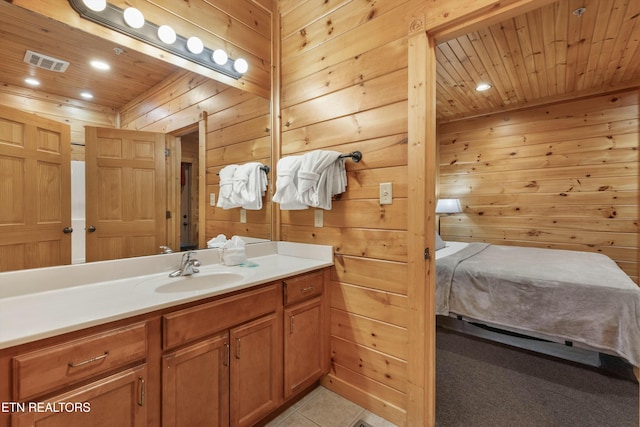 bathroom with tile patterned floors, vanity, wood ceiling, and wooden walls