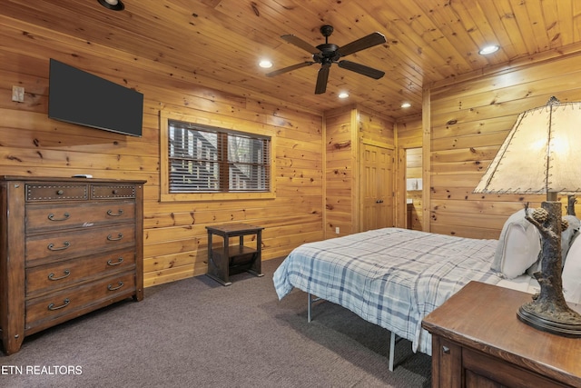 bedroom with wood walls, ceiling fan, wood ceiling, and dark colored carpet