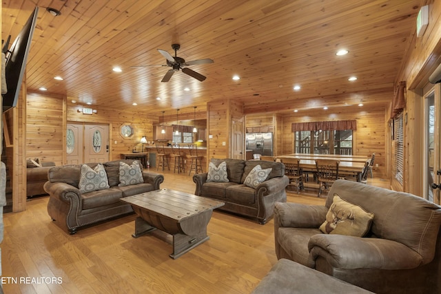 living room featuring wood ceiling, wooden walls, and light hardwood / wood-style floors