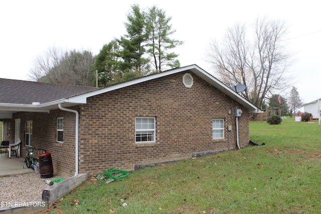 view of side of property featuring a yard and a patio area