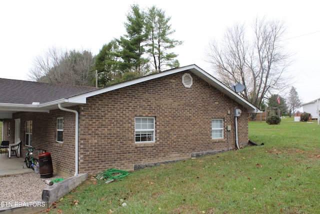 702 Iris Ave, Jamestown, TN 38556 - view of side of property with brick siding, a lawn, and a patio