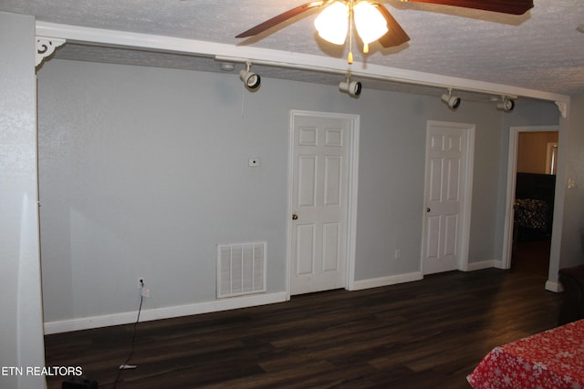 unfurnished bedroom featuring a textured ceiling, dark hardwood / wood-style floors, and ceiling fan