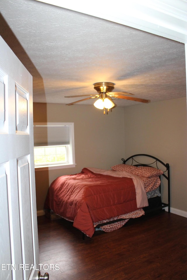 bedroom featuring a textured ceiling, dark hardwood / wood-style flooring, and ceiling fan