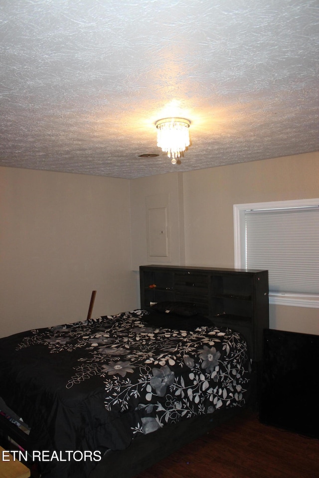 bedroom with wood-type flooring and a textured ceiling