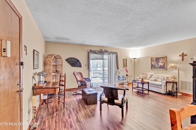 living room featuring a textured ceiling and hardwood / wood-style flooring