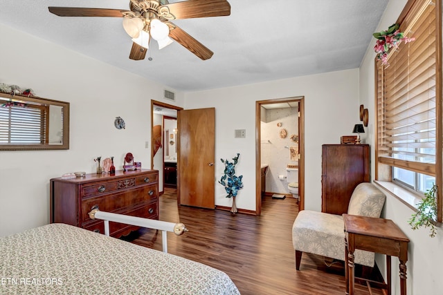 bedroom featuring ceiling fan, dark wood-type flooring, and ensuite bath