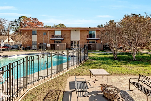 view of swimming pool with a yard, a patio, and a fire pit