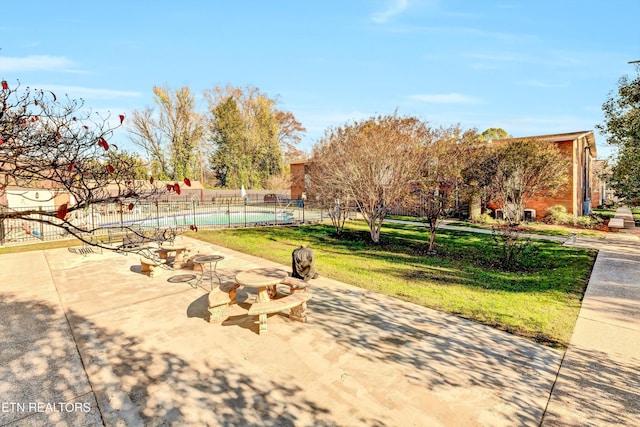 surrounding community featuring a patio, a pool, and a lawn