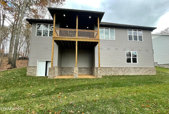 back of property featuring brick siding and a lawn