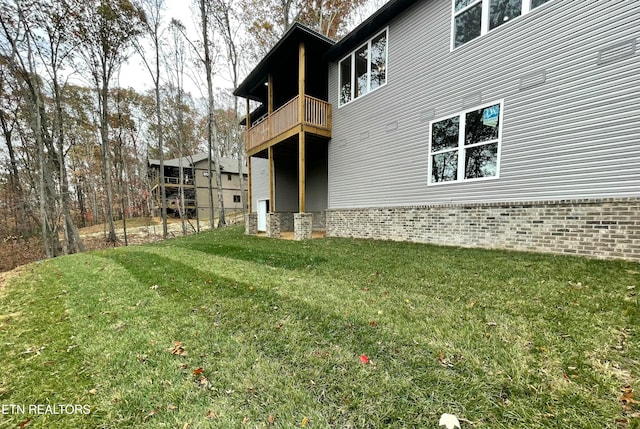 rear view of property with a balcony and a yard