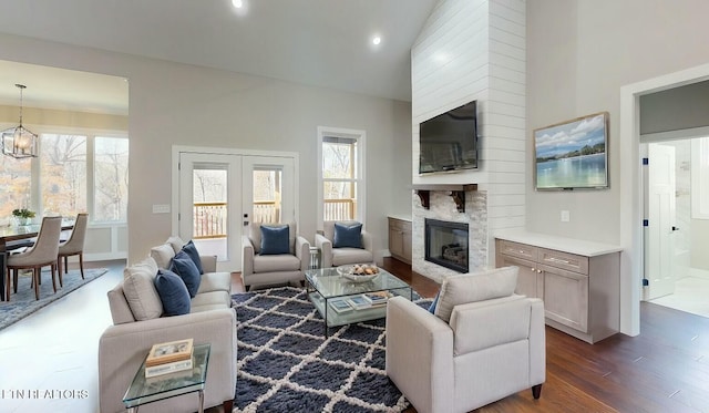 living room with a fireplace, a towering ceiling, recessed lighting, dark wood-style floors, and a notable chandelier