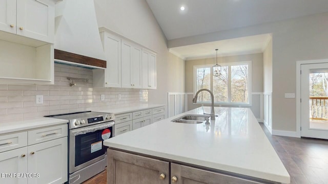 kitchen featuring decorative backsplash, light countertops, premium range hood, a sink, and stainless steel electric stove