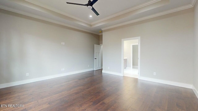 spare room featuring a ceiling fan, dark wood-style floors, a tray ceiling, and baseboards