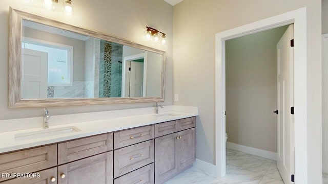 full bathroom featuring marble finish floor, a sink, toilet, and baseboards