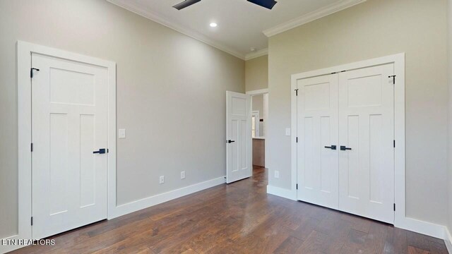unfurnished bedroom with a closet, crown molding, baseboards, ceiling fan, and dark wood finished floors