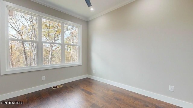 unfurnished room featuring ornamental molding, baseboards, dark wood-style floors, ceiling fan, and visible vents