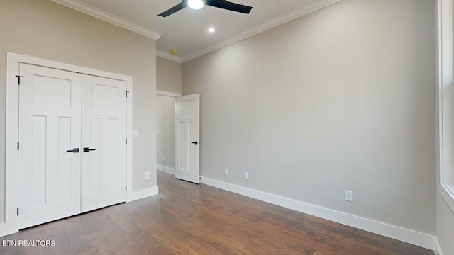 unfurnished bedroom with a closet, dark wood-type flooring, baseboards, ceiling fan, and ornamental molding
