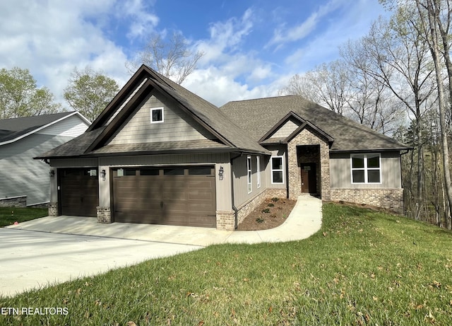 view of front of property featuring concrete driveway, roof with shingles, an attached garage, a front yard, and brick siding