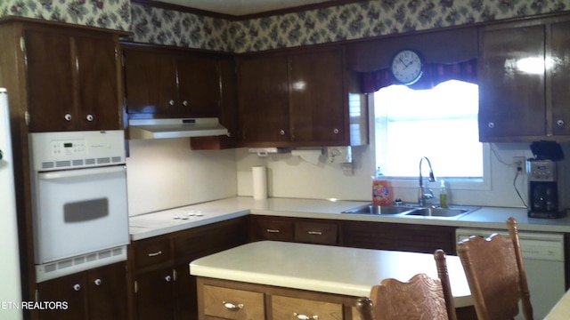 kitchen featuring dark brown cabinets, sink, and white appliances