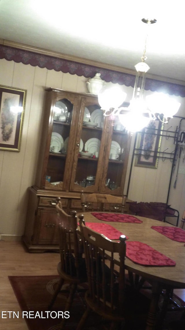 dining room with wood-type flooring and a notable chandelier