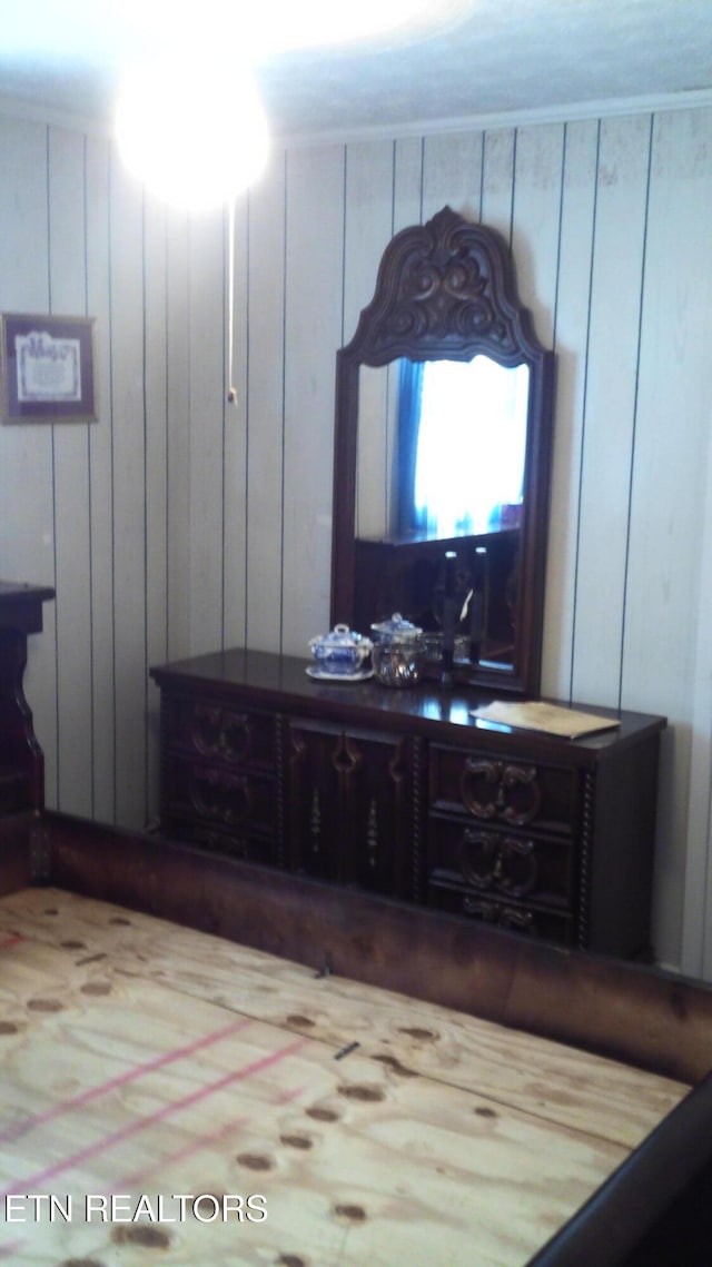 bedroom featuring wooden walls