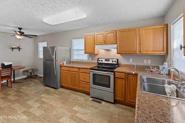 kitchen featuring a textured ceiling, ceiling fan, sink, and stainless steel appliances