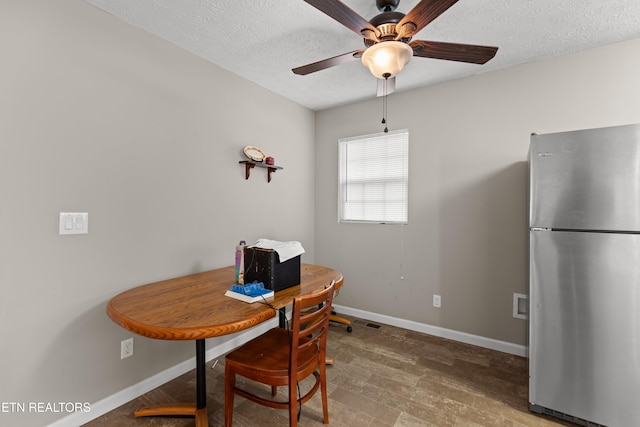 dining space with wood-type flooring, a textured ceiling, and ceiling fan