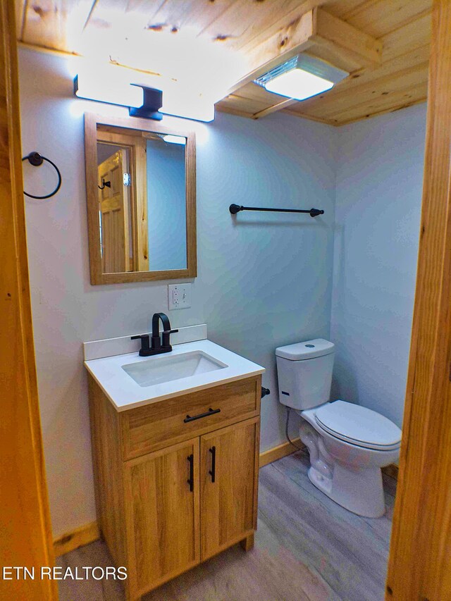 bathroom with hardwood / wood-style floors, vanity, toilet, and wood ceiling