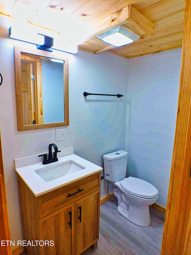 bathroom with hardwood / wood-style floors, vanity, toilet, and wood ceiling