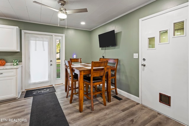 dining room with ceiling fan, ornamental molding, and light wood-type flooring