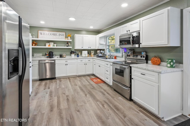 kitchen with sink, stainless steel appliances, crown molding, light hardwood / wood-style floors, and white cabinets