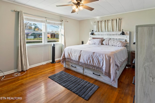 bedroom featuring ceiling fan, ornamental molding, and hardwood / wood-style flooring