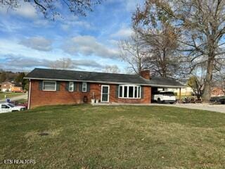 single story home featuring a carport and a front lawn