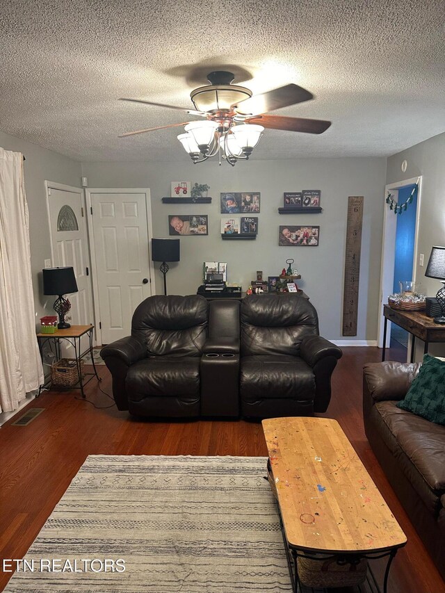 living room featuring a textured ceiling, ceiling fan, and dark hardwood / wood-style floors