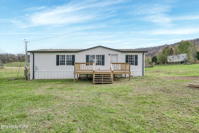 back of property with a yard and a wooden deck