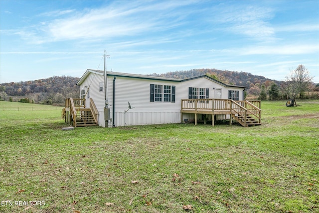 rear view of property with a yard and a wooden deck