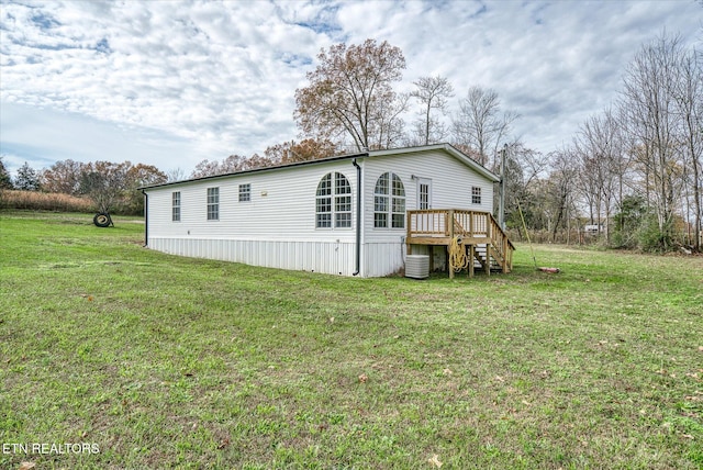 back of property with a yard and a deck