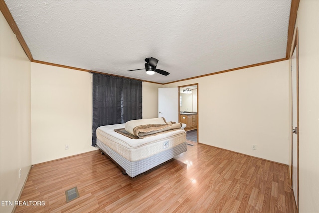 bedroom featuring wood-type flooring, a textured ceiling, ceiling fan, and ornamental molding