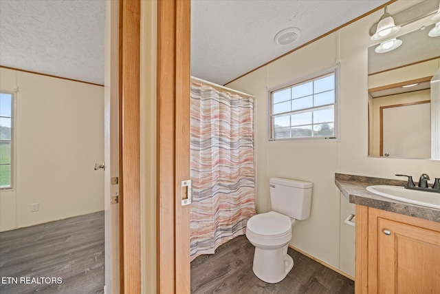 bathroom with vanity, hardwood / wood-style flooring, toilet, ornamental molding, and a textured ceiling