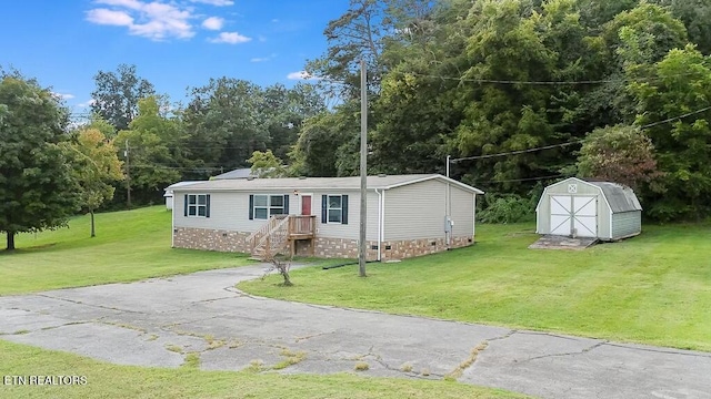 manufactured / mobile home with a front lawn and a shed