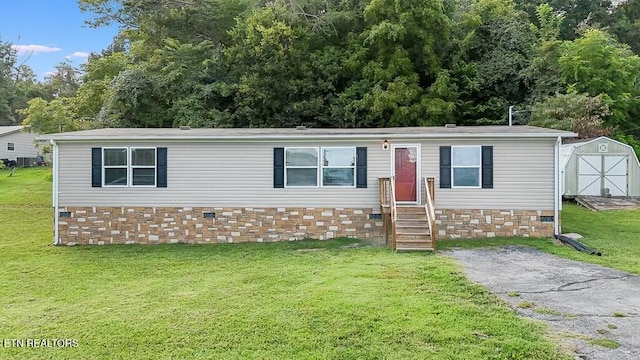 manufactured / mobile home with a shed and a front lawn