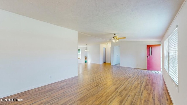 unfurnished room featuring a textured ceiling, ceiling fan, and light wood-type flooring