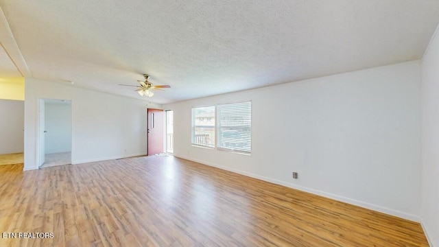 spare room featuring vaulted ceiling, ceiling fan, light hardwood / wood-style floors, and a textured ceiling