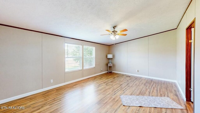 spare room featuring crown molding, a textured ceiling, ceiling fan, and light wood-type flooring