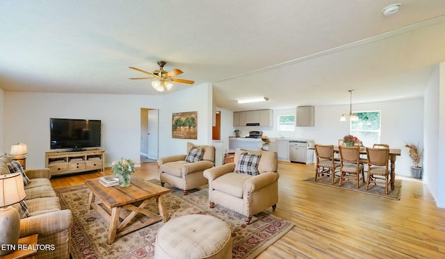 living room featuring ceiling fan and light hardwood / wood-style floors