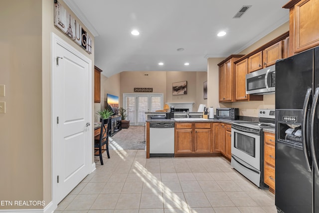 kitchen with sink, kitchen peninsula, appliances with stainless steel finishes, light tile patterned flooring, and ornamental molding