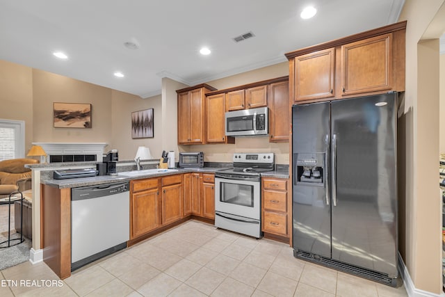 kitchen featuring sink, kitchen peninsula, appliances with stainless steel finishes, light tile patterned floors, and ornamental molding