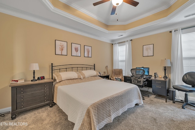 carpeted bedroom featuring a raised ceiling, ceiling fan, and ornamental molding