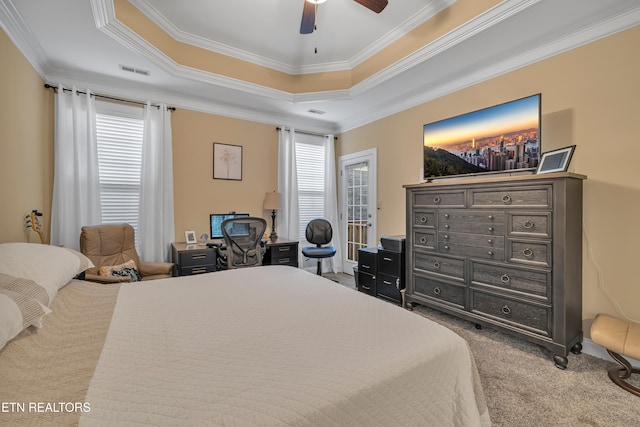 carpeted bedroom featuring a raised ceiling, ceiling fan, and ornamental molding